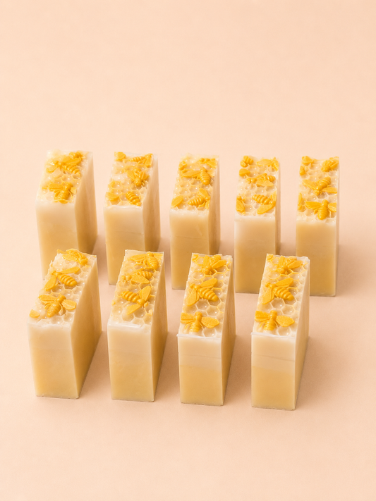 Row of rectangular soap bars with yellow flower petals on a beige background