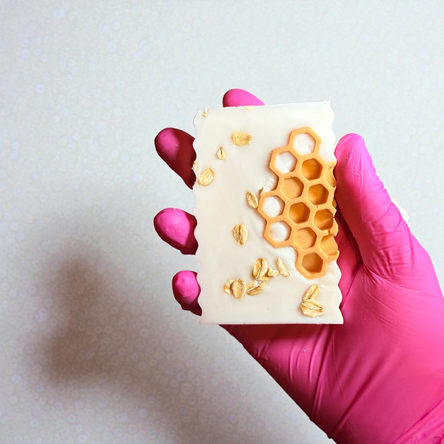 Rectangle shea butter soap with oatmeal, milk, and honey scent, decorated with orange honeycombs and oats