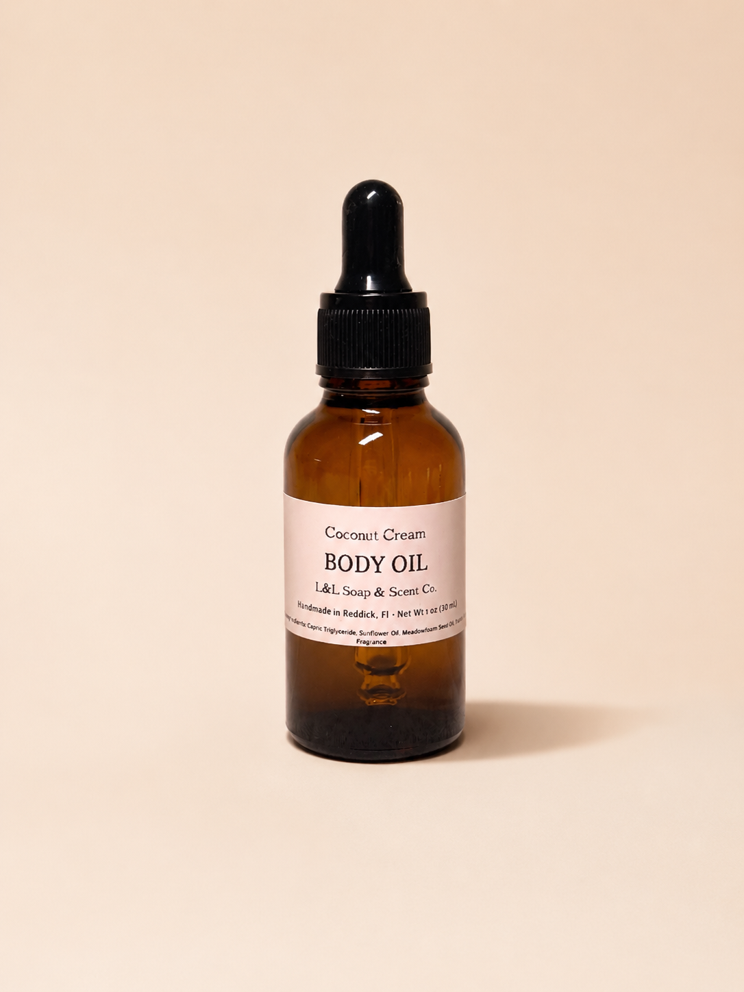 Coconut cream body oil bottle with dropper on a beige background