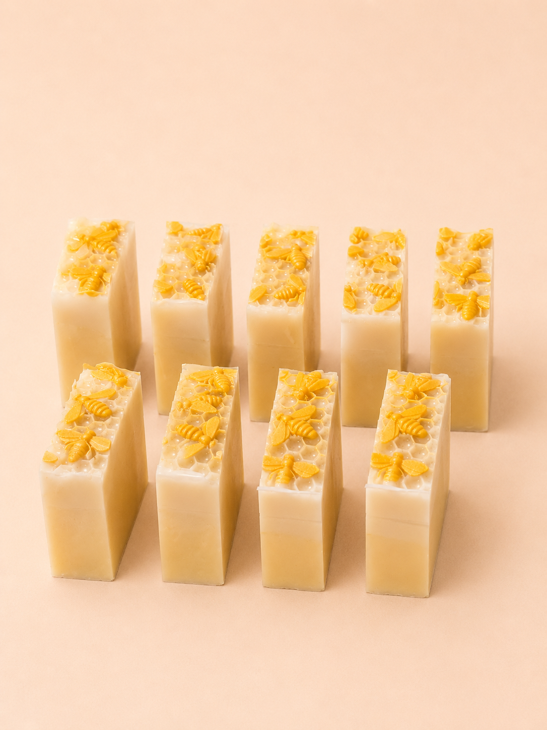 Row of rectangular soap bars with yellow flower petals on a beige background