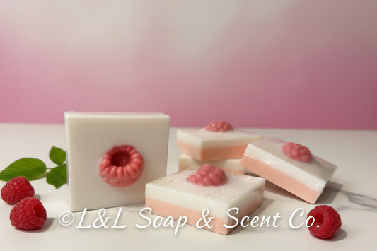 Square white and pink shea butter soap, raspberries and cream scented, with a pink raspberry decoration in the center