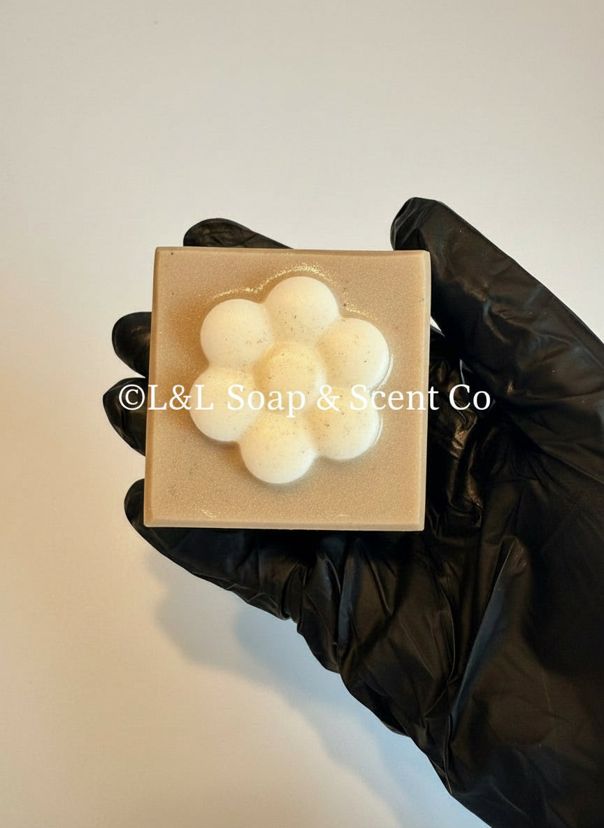 Brown square shape lavender vanilla essential oil Shea butter soaps with white flower in middle.